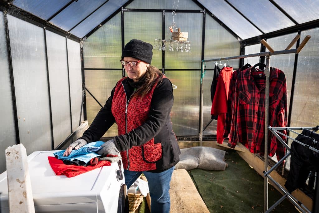 Tricia in the greenhouse as a makeshift laundry post flood